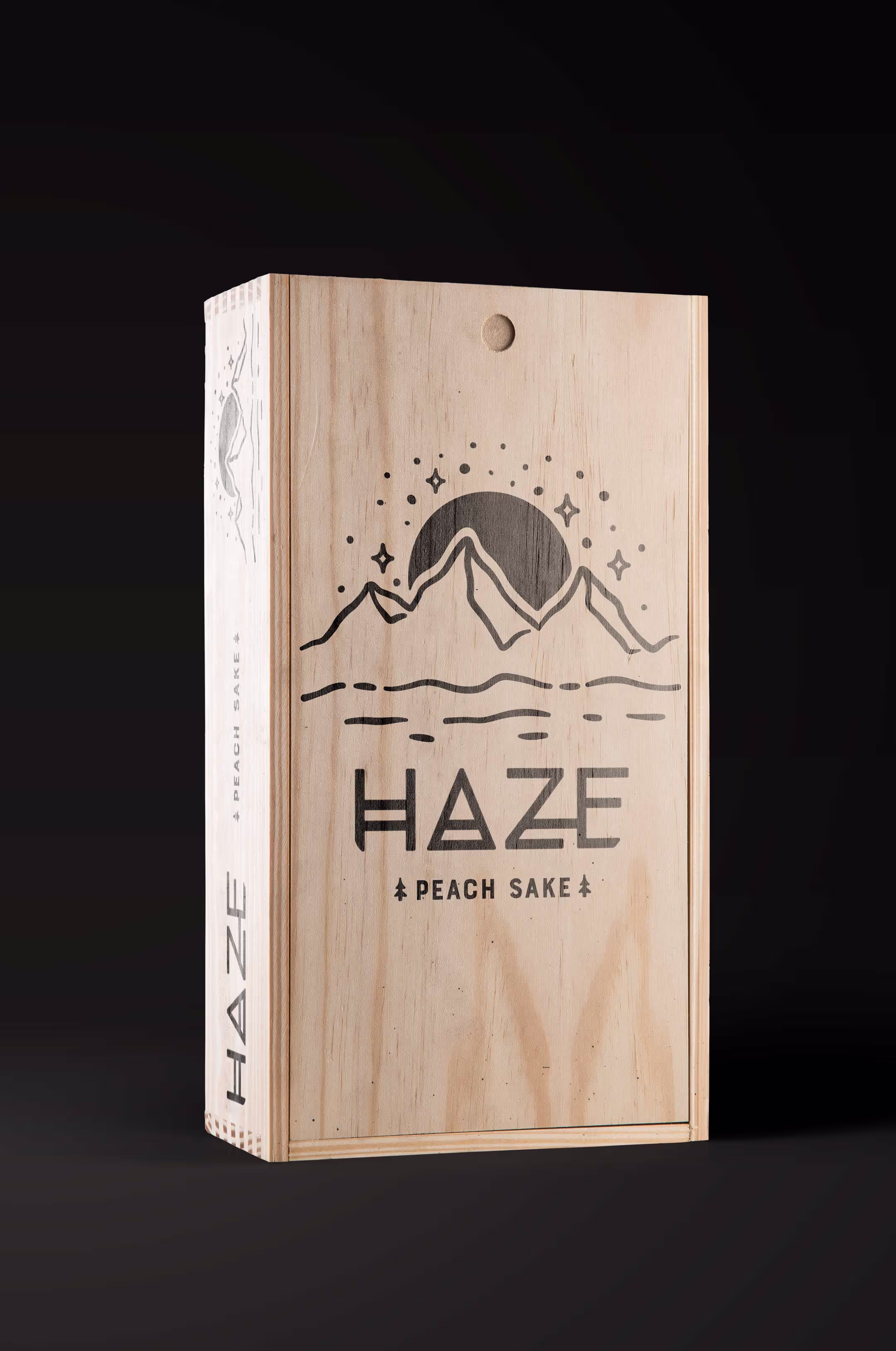 The wooden outer packaging of the Haze Sake set, showing the detailed printed logo on the front.