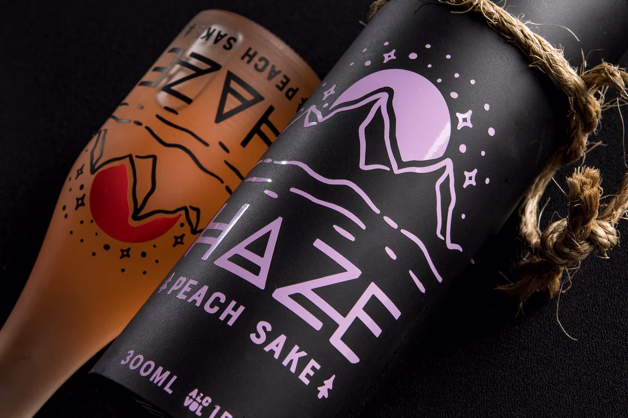 A close-up look at the peach sake variation of the Haze Sake set, showcasing the detailed vinyl labeling, vibrant coloring, and intricate branding.